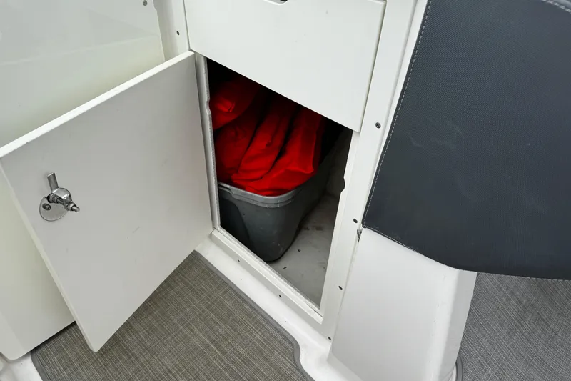 Slide: The Image of Open storage compartment on 2020 Chaparral 277 SSX boat with red life jackets inside. - 30