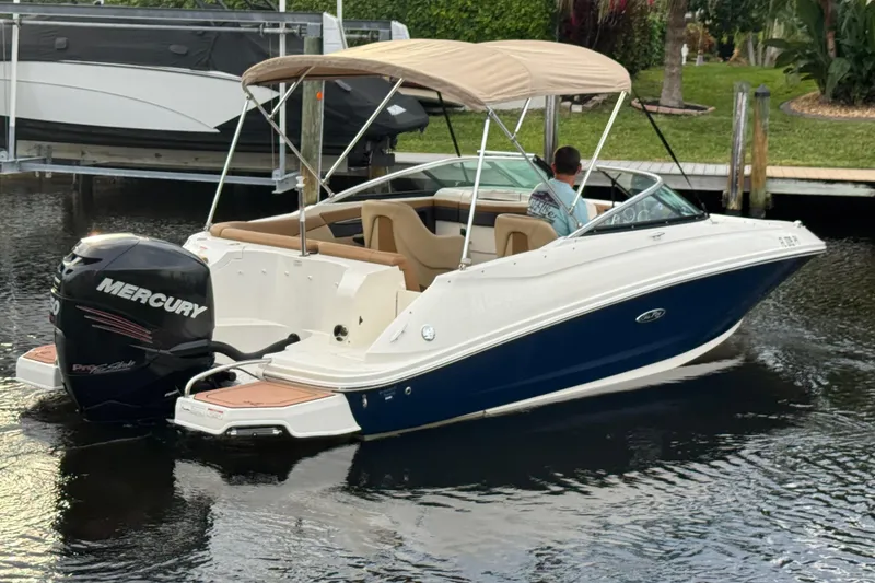 Slide: The Image of 2015 Sea Ray 220 Sundeck Outboard boat with Mercury engine on calm water. - 10