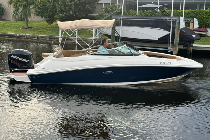 Slide: The Image of 2015 Sea Ray 220 Sundeck Outboard boat with Mercury engine on a calm waterway. - 12