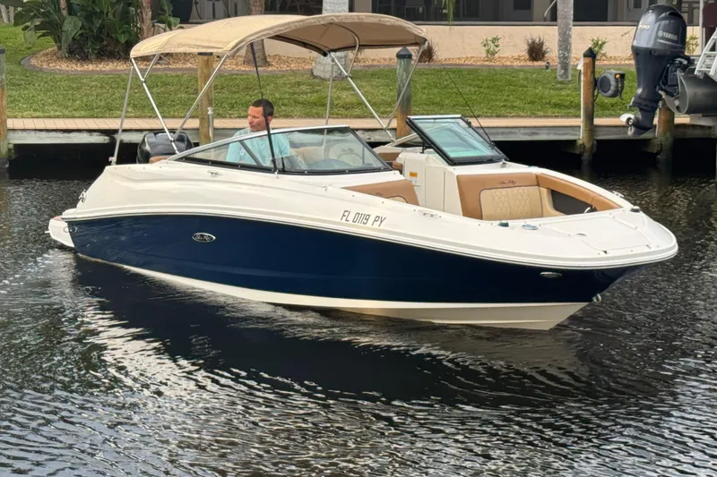Slide: The Image of 2015 Sea Ray 220 Sundeck Outboard boat cruising on a calm waterway. - 15