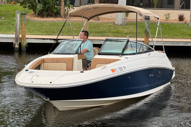 Slide: The Image of 2015 Sea Ray 220 Sundeck Outboard boat cruising on a calm waterway. - 16
