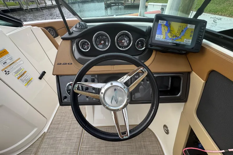 Slide: The Image of 2015 Sea Ray 220 Sundeck Outboard dashboard with steering wheel and Garmin GPS. - 17