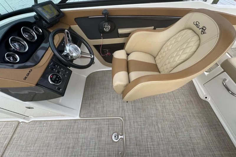 Slide: The Image of 2015 Sea Ray 220 Sundeck Outboard helm with luxurious seating and modern controls. - 18