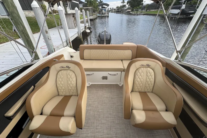 Slide: The Image of 2015 Sea Ray 220 Sundeck Outboard interior with luxurious seating by the water. - 22