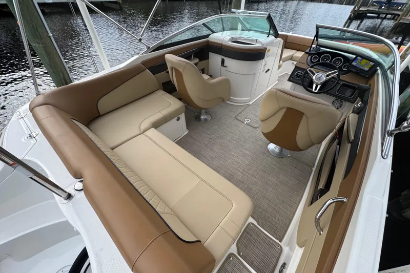 Slide: The Image of 2015 Sea Ray 220 Sundeck Outboard interior with beige seating and modern dashboard. - 23