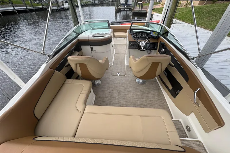 Slide: The Image of 2015 Sea Ray 220 Sundeck Outboard interior with tan seating and modern dashboard. - 24