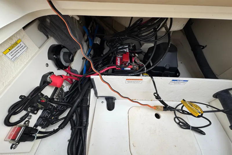 Slide: The Image of 2015 Sea Ray 220 Sundeck Outboard engine compartment with wiring and battery setup. - 36