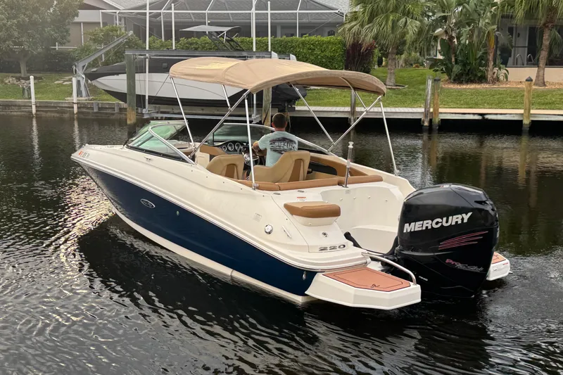 The Image of 2015 Sea Ray 220 Sundeck Outboard boat with Mercury engine on a calm waterway. - 9