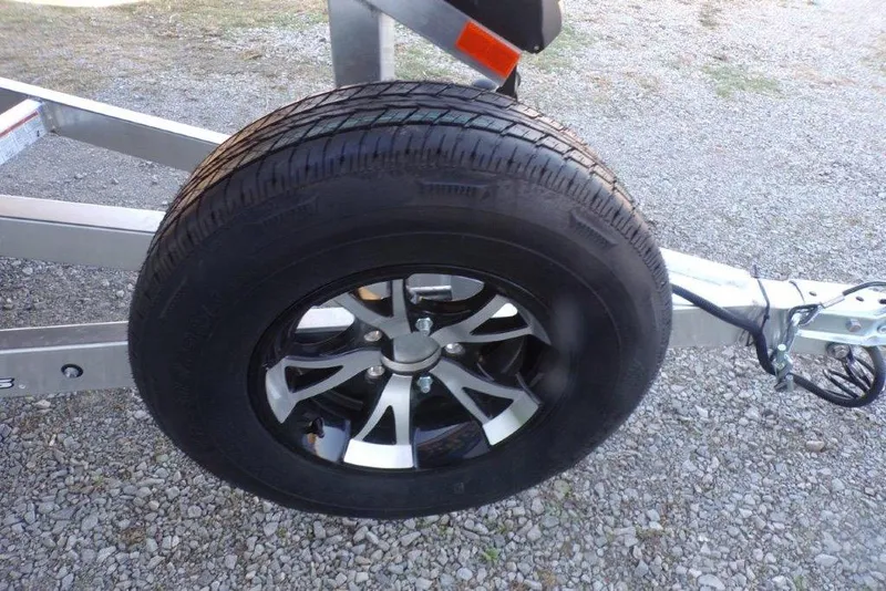 Slide: The Image of 2026 Xpress H20B Bay trailer wheel on gravel surface. - 11