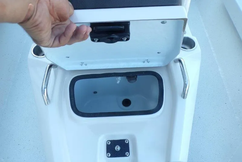 Slide: The Image of Open storage compartment on 2026 Xpress H20B Bay boat with hand lifting lid. - 19