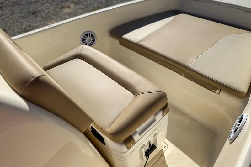 Slide: The Image of 2026 Scout 175 Sportfish boat interior with beige cushioned seating and built-in storage. - 18