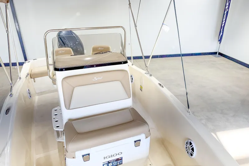 Slide: The Image of 2026 Scout 175 Sportfish boat interior with beige seating and Igloo cooler. - 23
