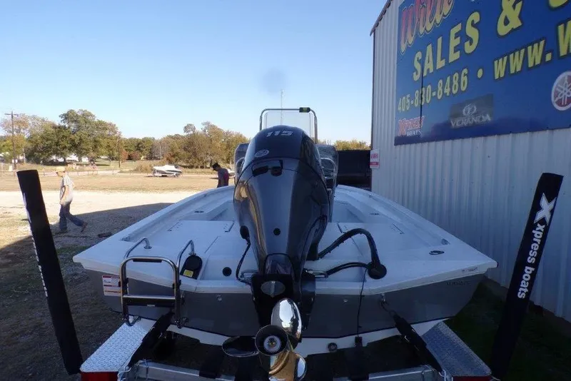 Slide: The Image of 2026 Xpress H20B Bay boat with outboard motor at dealership. - 1