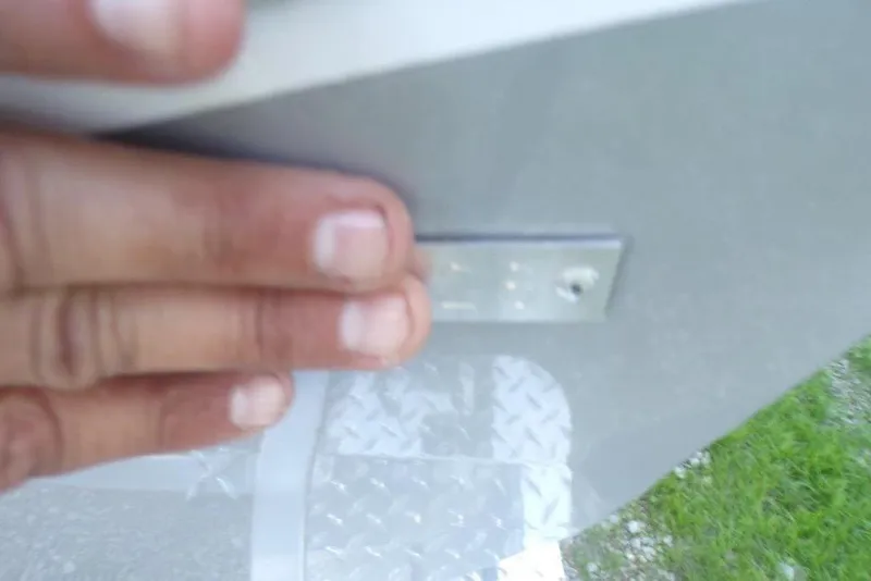 Slide: The Image of Hand holding a metal plate on a 2026 Xpress H20B Bay boat. - 4