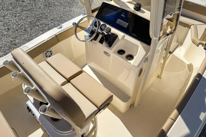 Slide: The Image of 2026 Scout 215 XSF boat interior with steering console and seating, featuring beige upholstery. - 24