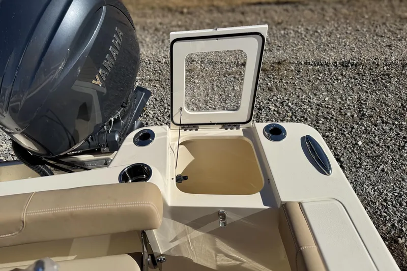 Slide: The Image of 2026 Scout 215 XSF boat with Yamaha engine, open storage compartment, and beige seating. - 25