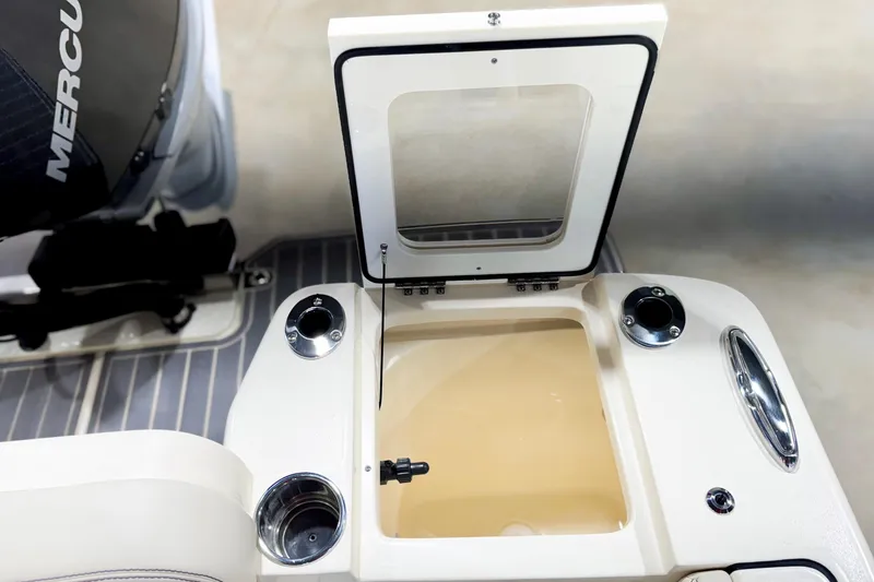 Slide: The Image of 2026 Scout 240 XSF boat interior with open storage compartment and Mercury engine. - 28