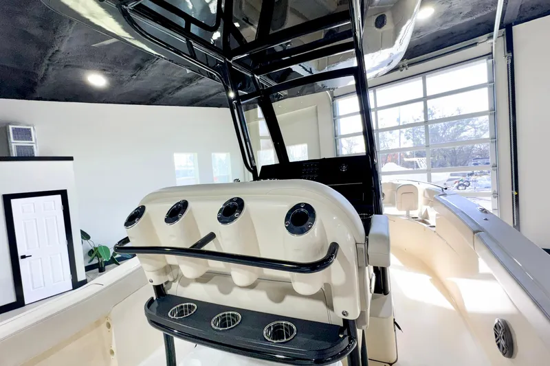 Slide: The Image of 2026 Scout 240 XSF boat interior with rod holders and sleek design in showroom. - 29