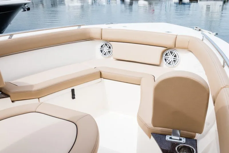 Slide: The Image of 2026 Scout 240 XSF boat interior with beige seating and speaker. - 4