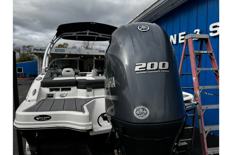 Slide: The Image of 2023 Chaparral 21 SSi OB boat with Yamaha 200 engine, parked near blue building. - 27