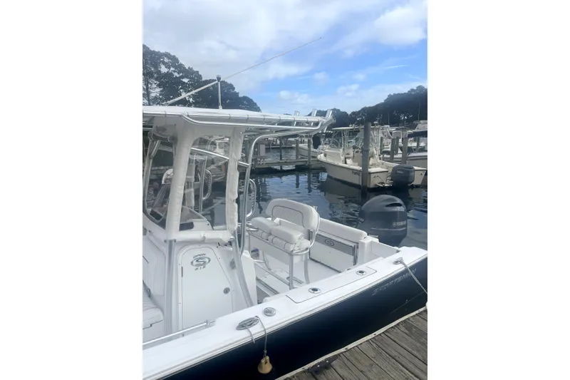 Slide: The Image of 2021 Sportsman Heritage 211 Center Console boat docked at marina, clear sky background. - 2