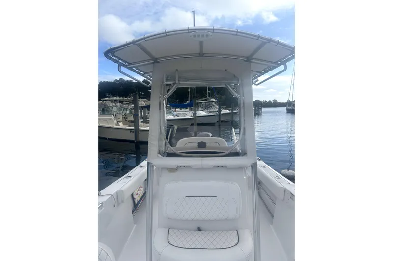 Slide: The Image of 2021 Sportsman Heritage 211 Center Console boat docked at marina, featuring T-top and seating. - 6