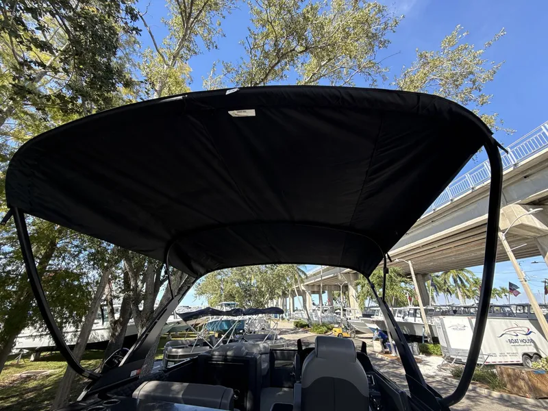 Slide: The Image of Sanpan 2500 MTF 2026 pontoon boat with canopy, docked under a clear blue sky. - 13