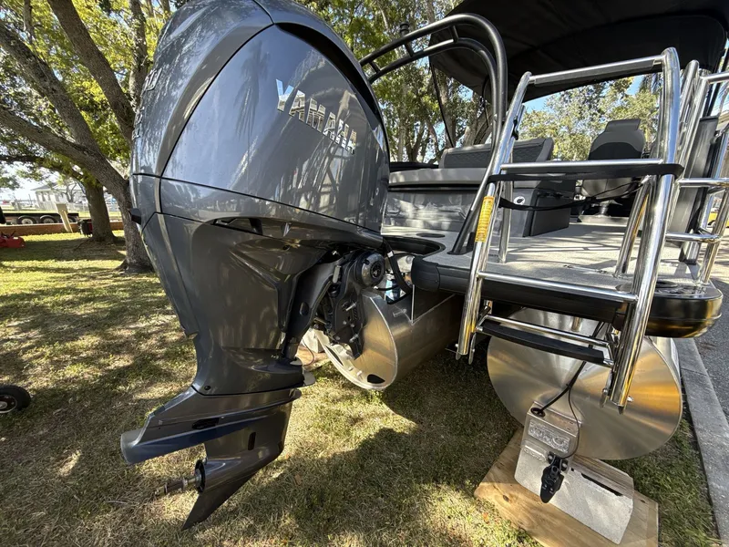 Slide: The Image of 2026 Sanpan 2500 MTF pontoon boat with Yamaha outboard motor and ladder, parked on grass. - 16
