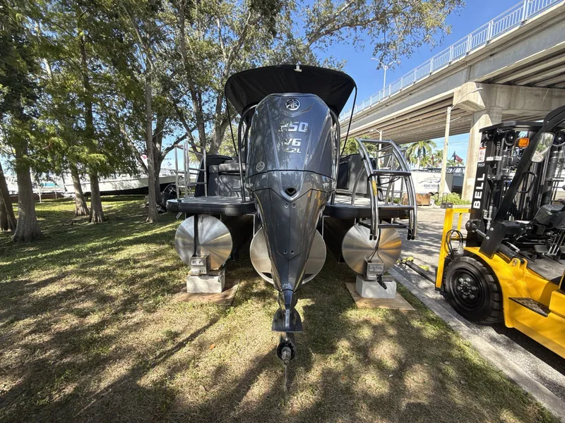 Slide: The Image of Sanpan 2500 MTF 2026 pontoon boat displayed outdoors near trees and a bridge. - 3