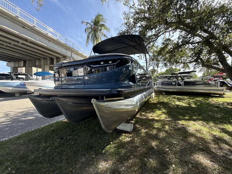 Slide: The Image of Sanpan 2500 MTF pontoon boat displayed outdoors, under a bridge, surrounded by trees. - 8