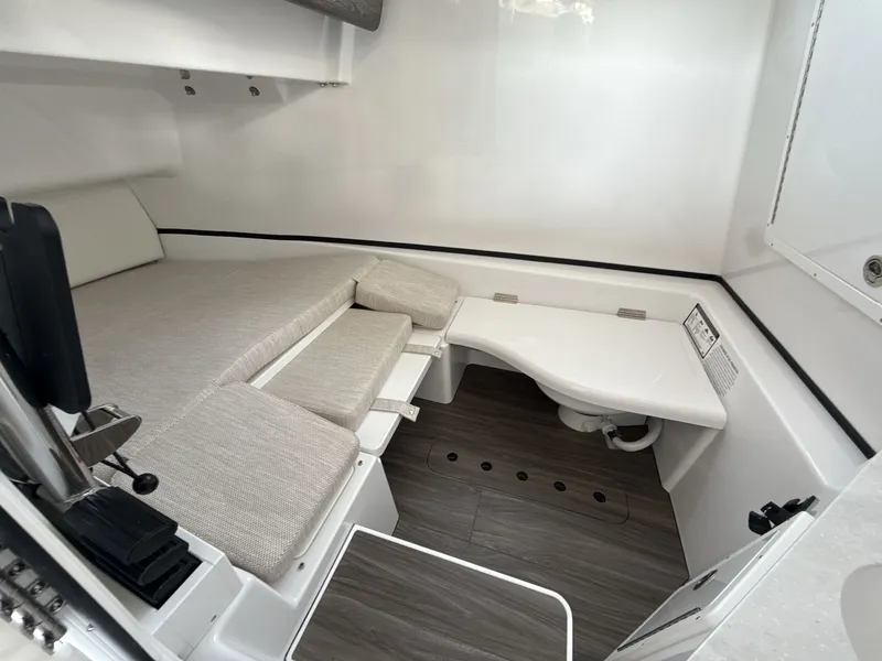 Slide: The Image of 2026 Sportsman Open 352 Center Console cabin interior with seating and compact toilet. - 13