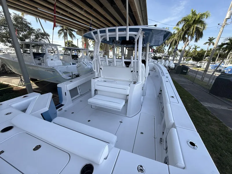 Slide: The Image of 2026 Sportsman Open 352 Center Console boat, spacious deck, under a bridge, palm trees in background. - 16