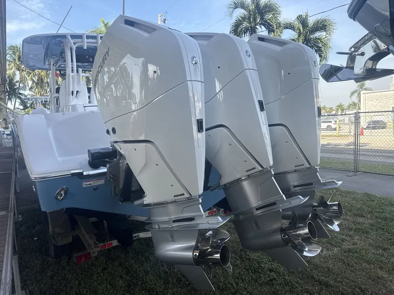 Slide: The Image of 2026 Sportsman Open 352 Center Console with triple outboard engines, parked outdoors. - 18