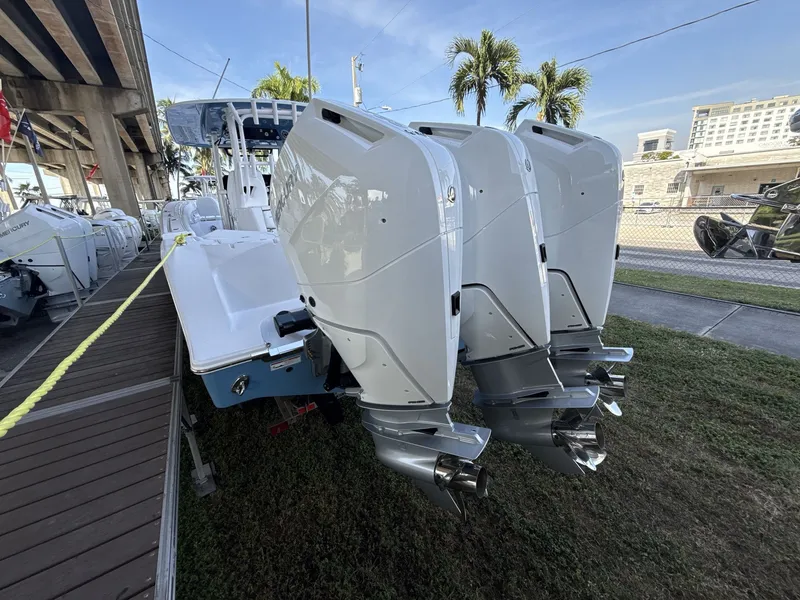 Slide: The Image of 2026 Sportsman Open 352 Center Console with triple outboard engines, docked under a bridge. - 4