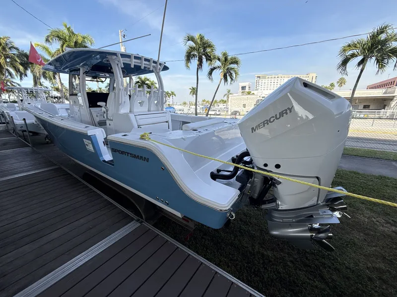 Slide: The Image of 2026 Sportsman Open 352 Center Console boat with Mercury engine, docked under palm trees. - 9