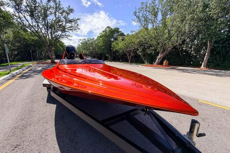 Slide: The Image of 1984 Sleekcraft Aristocrat 20 boat with vibrant red finish on a trailer, surrounded by trees. - 10