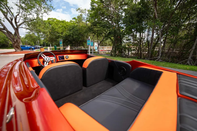 Slide: The Image of 1984 Sleekcraft Aristocrat 20 boat interior with orange and black seating, parked near trees. - 14
