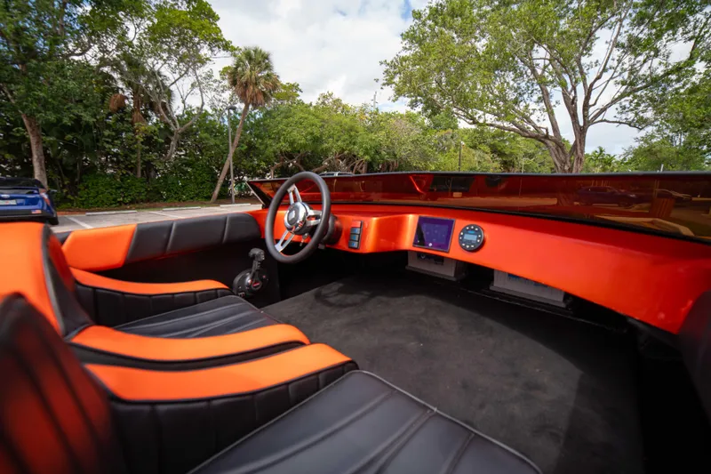 Slide: The Image of 1984 Sleekcraft Aristocrat 20 boat interior with orange and black seating, steering wheel, and dashboard. - 16