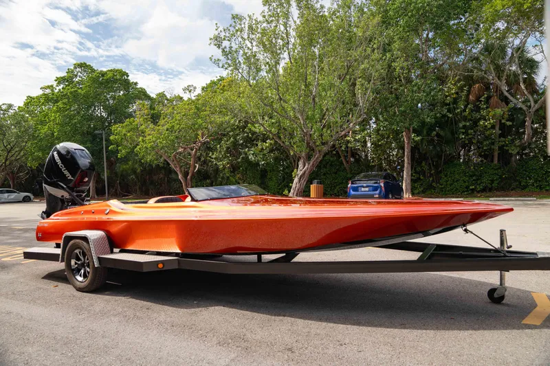 Slide: The Image of 1984 Sleekcraft Aristocrat 20 boat on trailer, vibrant orange, parked outdoors. - 19