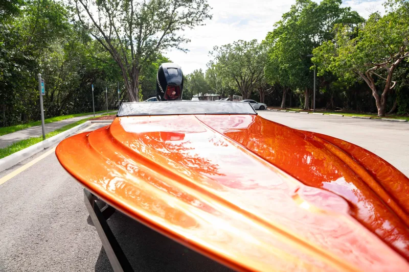 Slide: The Image of 1984 Sleekcraft Aristocrat 20 boat with vibrant orange finish, parked on a sunny street. - 21