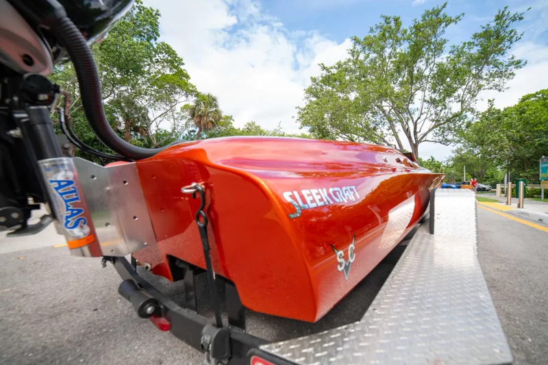 Slide: The Image of 1984 Sleekcraft Aristocrat 20 boat on trailer, vibrant orange, parked outdoors. - 5
