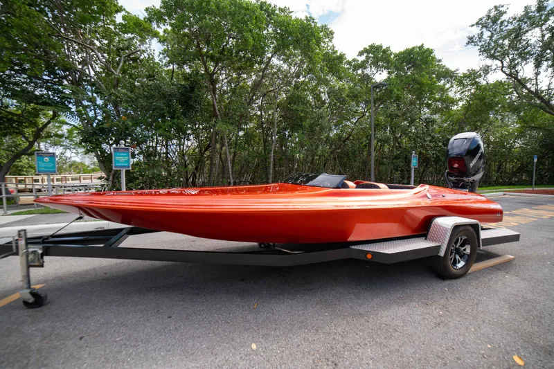 Slide: The Image of 1984 Sleekcraft Aristocrat 20 boat on trailer, vibrant orange, parked near lush greenery. - 7