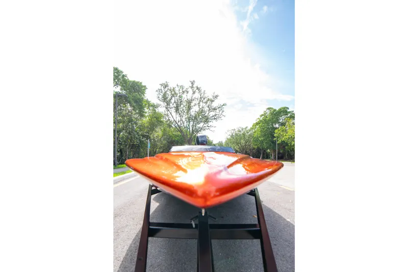 Slide: The Image of 1984 Sleekcraft Aristocrat 20 boat on trailer, vibrant orange hull, sunny day, tree-lined road. - 8
