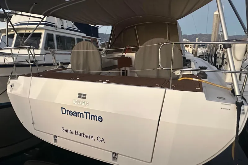 Slide: The Image of 2022 Bavaria C45 yacht docked, featuring a shaded deck and sleek design. - 7