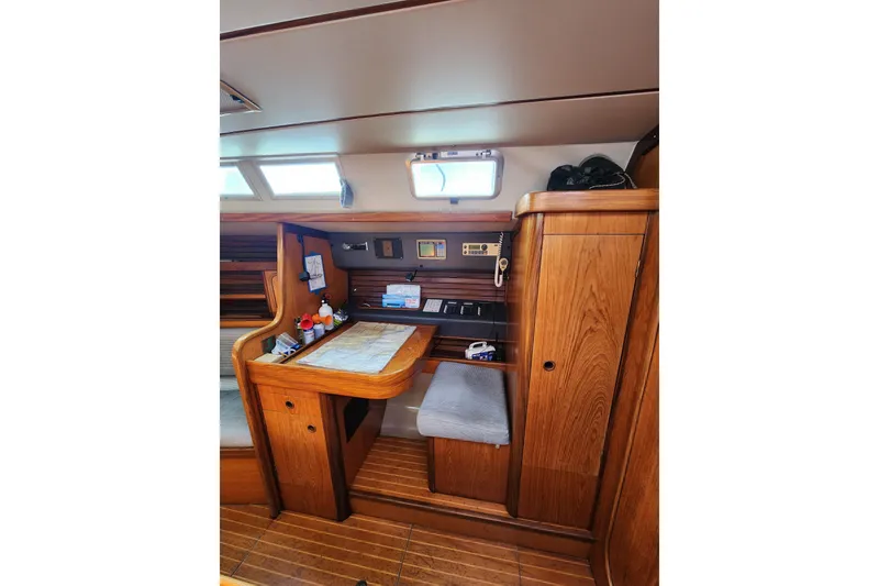 Slide: The Image of Interior of 1988 Beneteau First 405 sailboat with wooden navigation station and seating. - 14