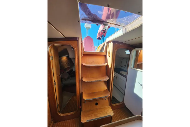 Slide: The Image of Interior view of 1988 Beneteau First 405 sailboat, featuring wooden stairs and cabin access. - 15
