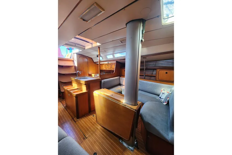 Slide: The Image of Interior of 1988 Beneteau First 405 sailboat, featuring wood finishes and cozy seating area. - 16