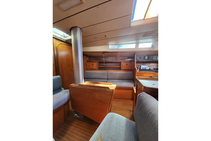 Slide: The Image of Interior of 1988 Beneteau First 405 sailboat, featuring wood paneling and seating area. - 19
