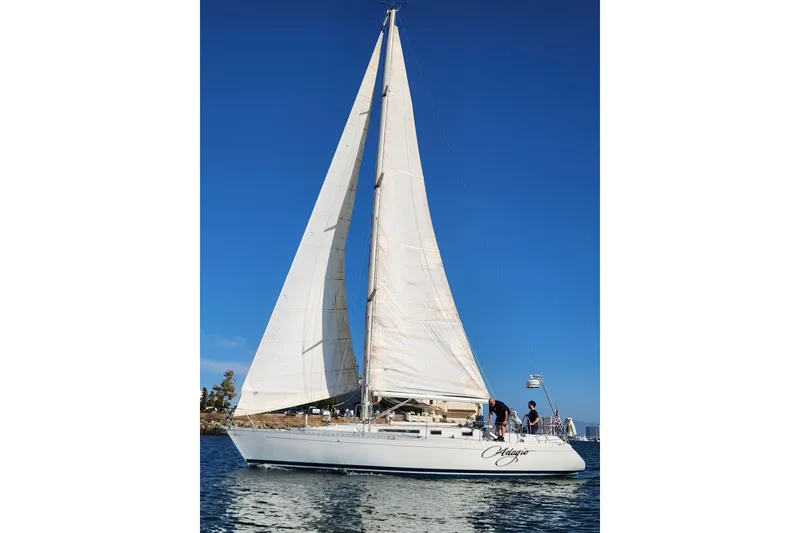 Slide: The Image of 1988 Beneteau First 405 sailboat on water, clear blue sky background. - 2