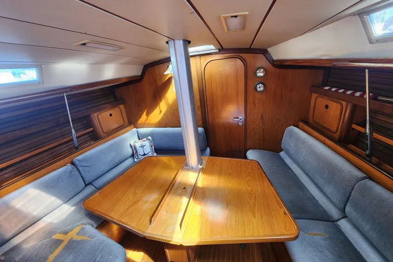 Slide: The Image of Interior of 1988 Beneteau First 405 sailboat with wooden table and blue seating. - 20